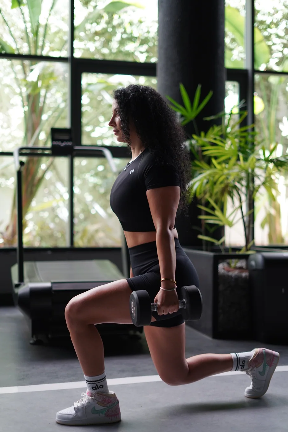Ceece performing a dumbbell lunge in the gym