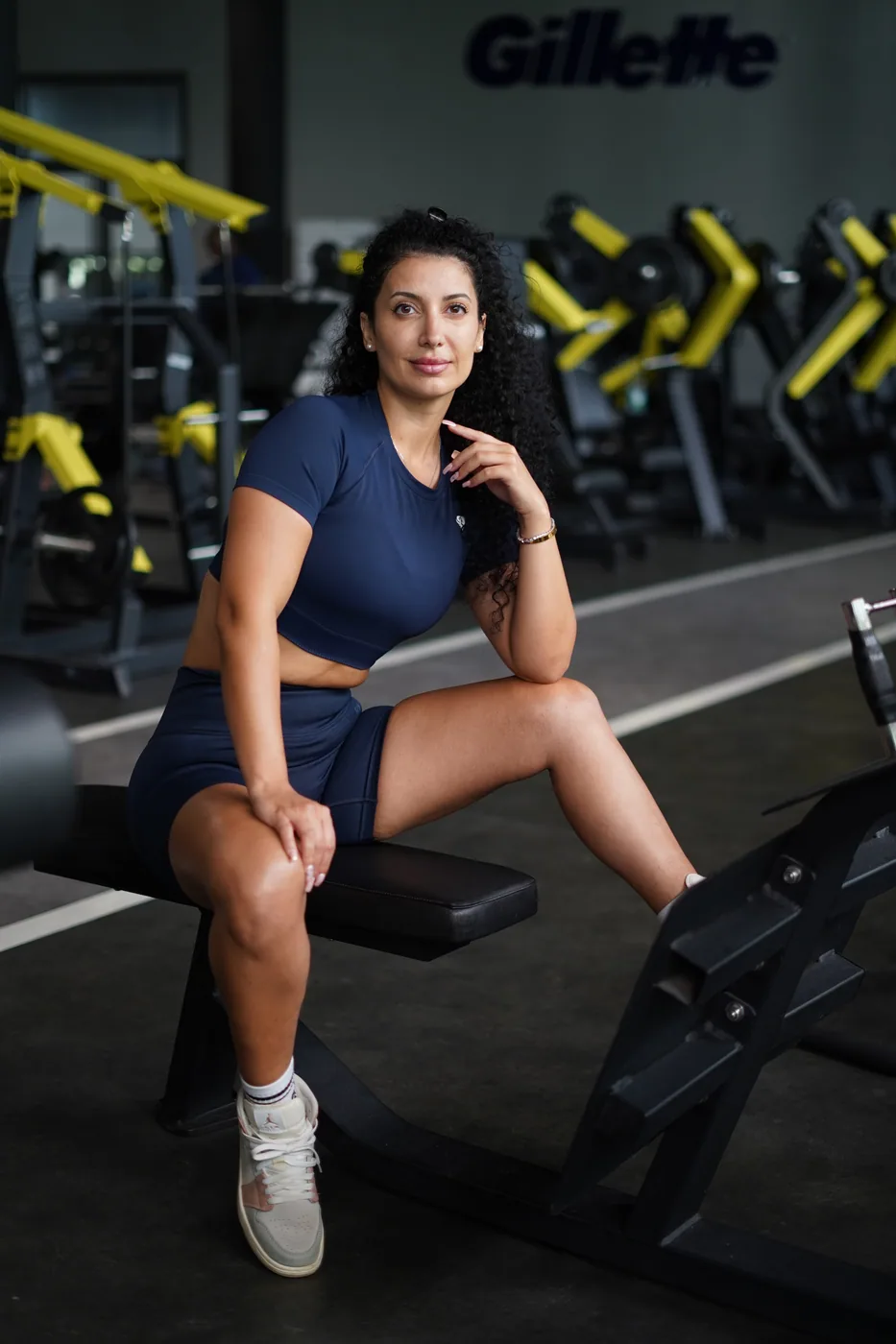 Ceece seated on a weight bench
